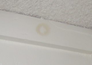 What is causing/caused these brown circular stains in my cabinetry?